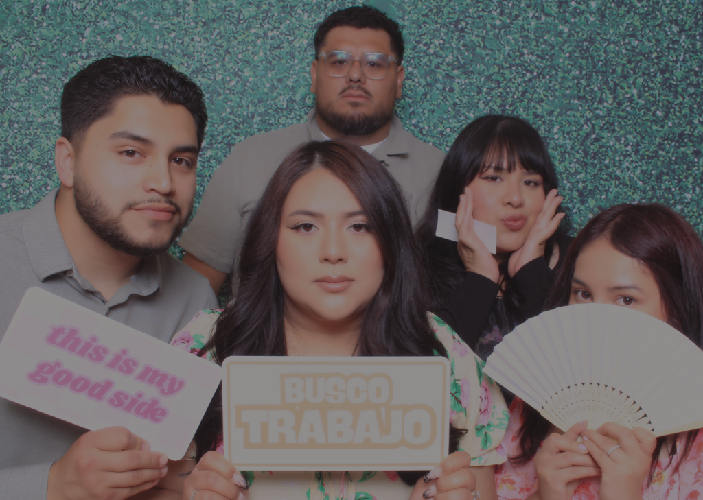 Group of guests posing at a Core Memories Photo Booth event holding fun signs
