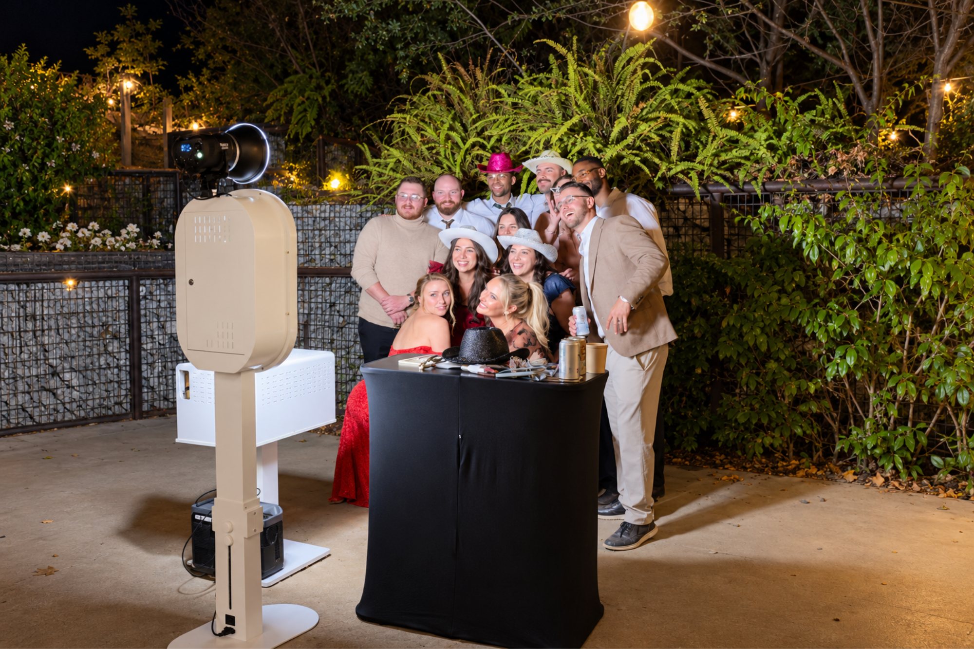 Wood photo booth and guests at an outdoor evening celebration