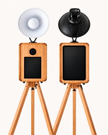 Two wooden Signature photo booth setups with touchscreens and lights