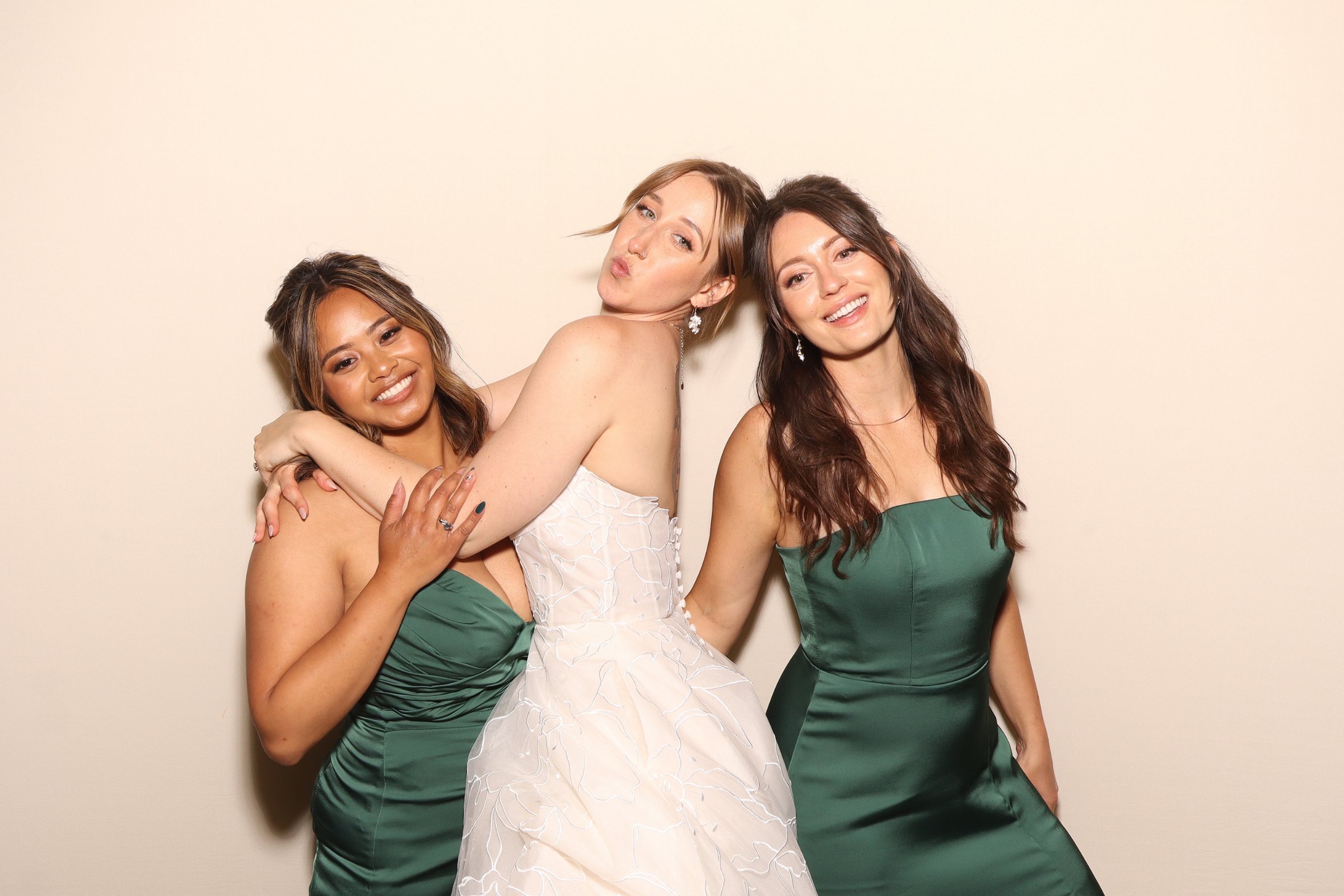 Bride and two guests posing together at the photo booth